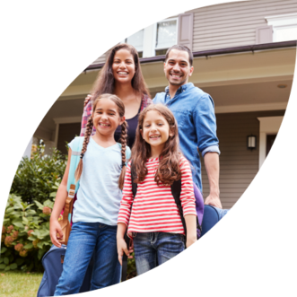 Family standing in front of their home, ready for travel